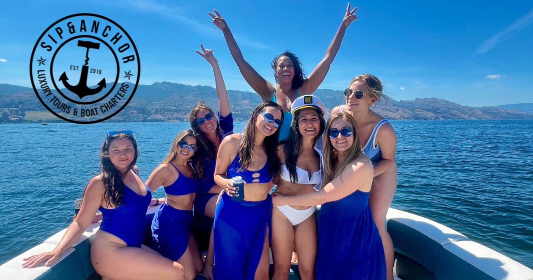 Friends posing on boat enjoying sunny day on blue lake