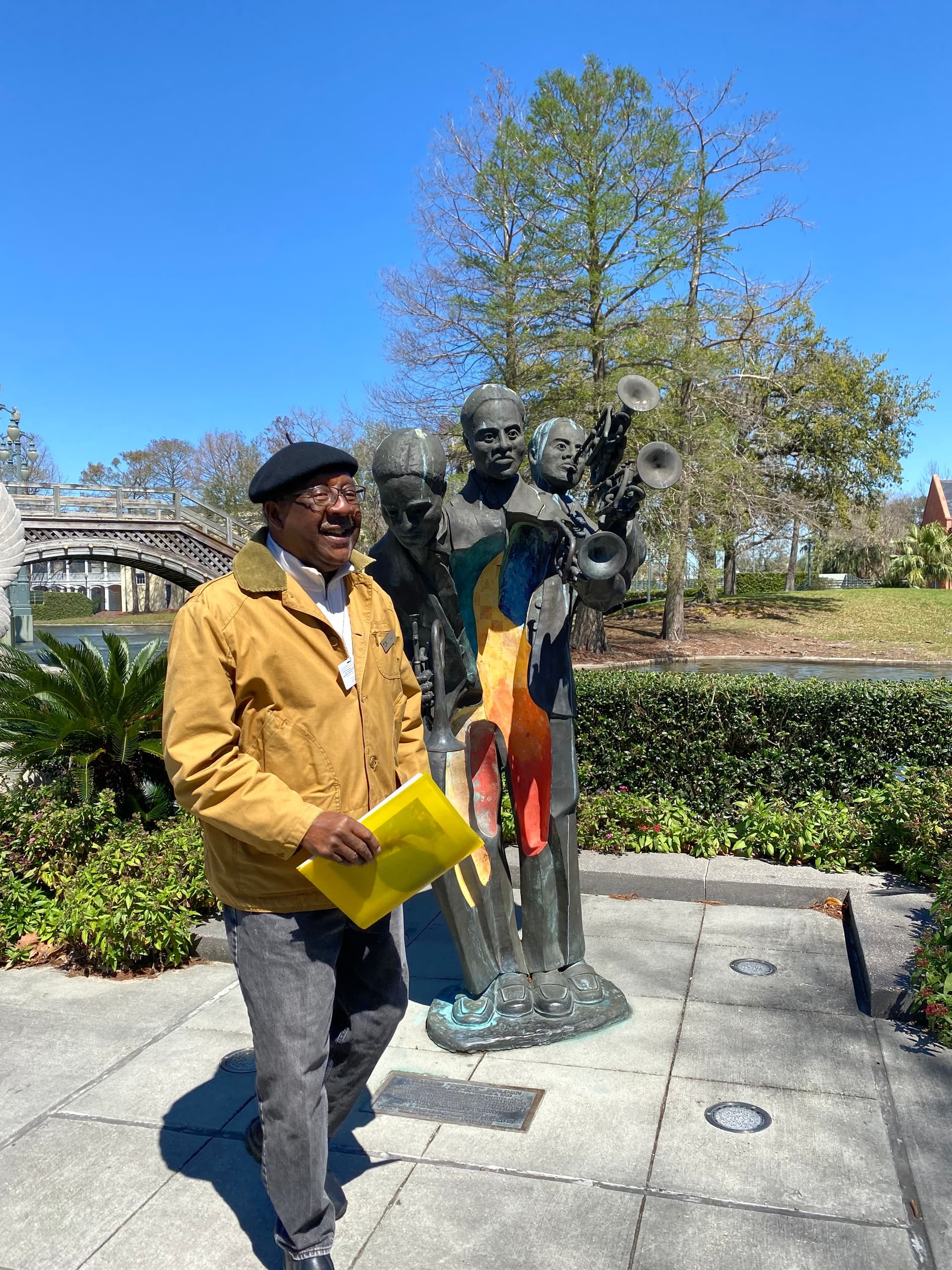 Local guide reading map beside jazz musicians statue in New Orleans park