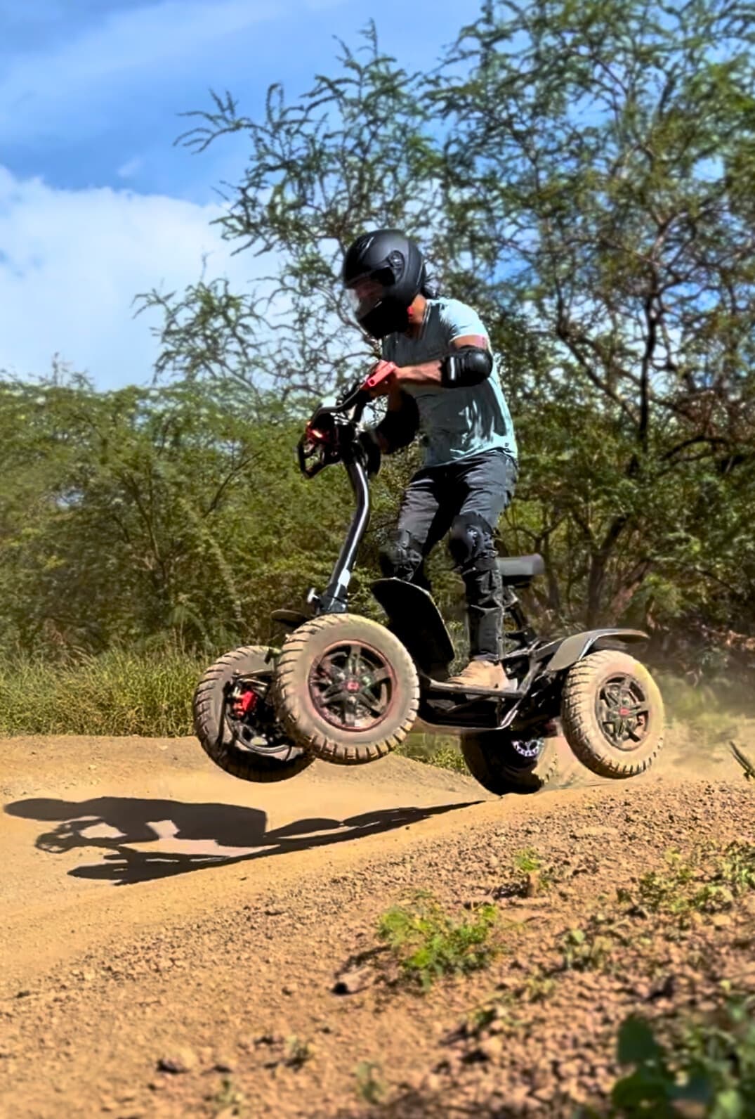 Rider jumping electric off-road board on rugged dirt trail