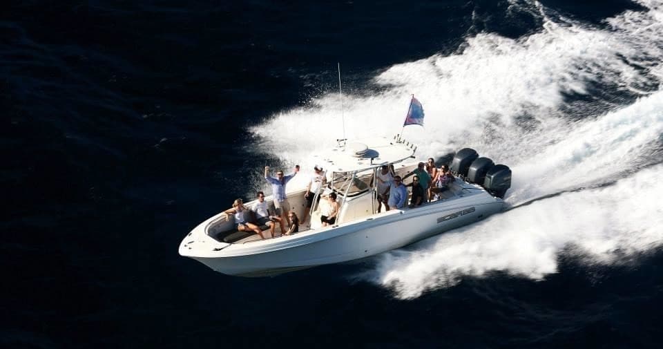 High-speed rigid inflatable boat slicing dark open ocean with passengers