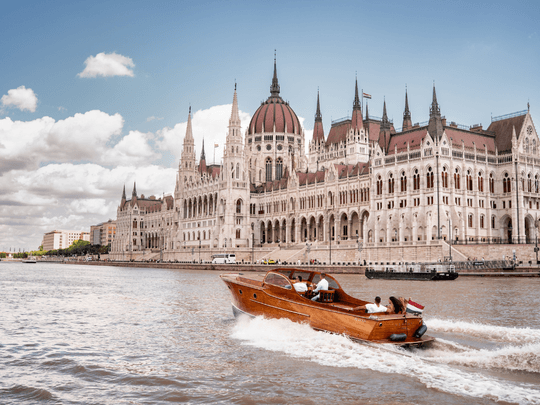 Sightseeing boat cruising past Budapest Parliament on Danube