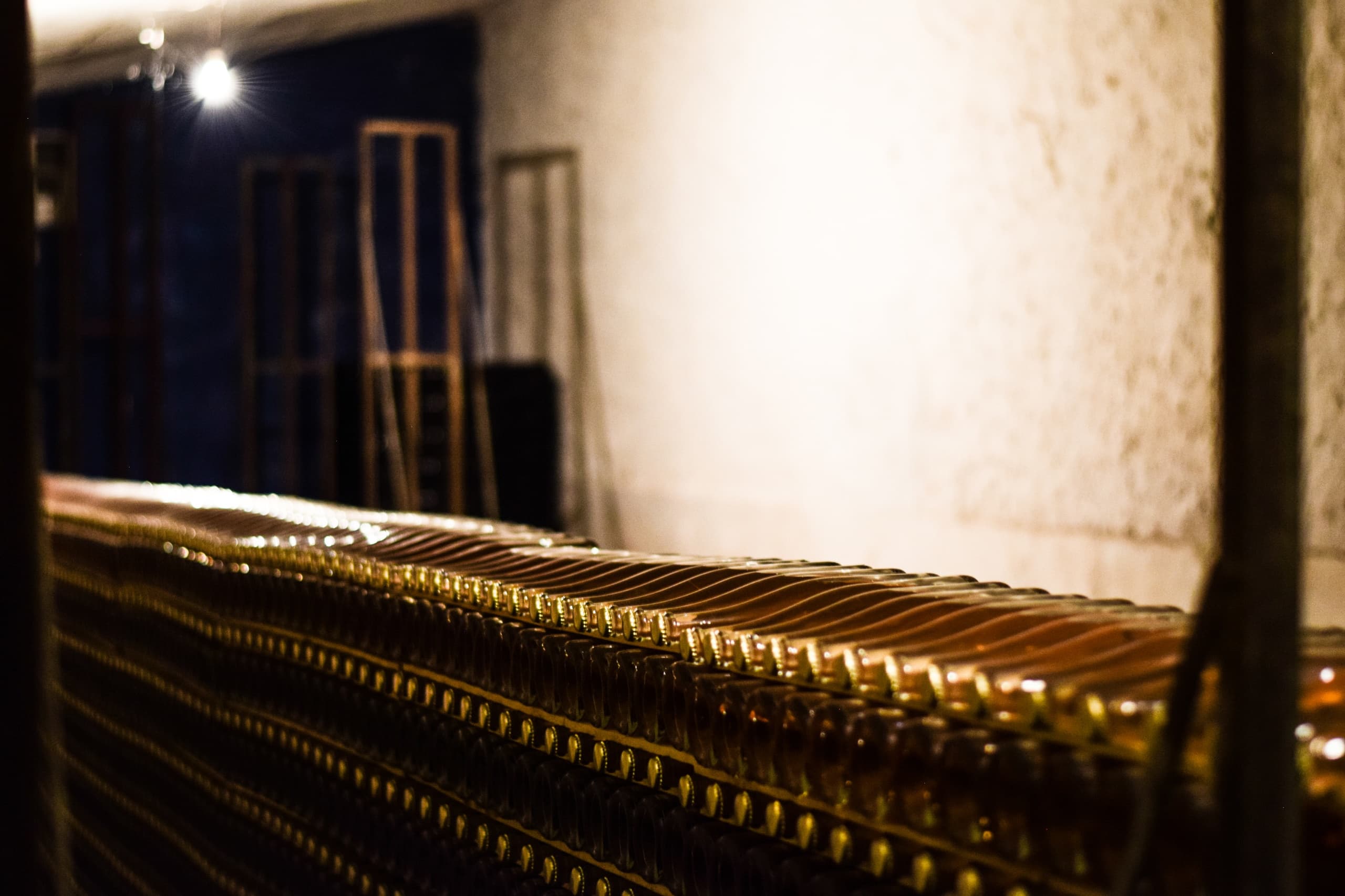 Rows of wine bottles aging in a cellar during wine production