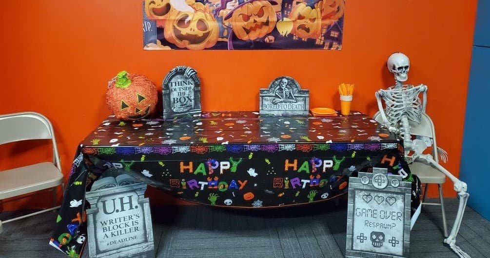 Halloween party table display with skeleton in indoor event space