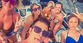 Group of friends posing on boat deck enjoying sunny gulf outing
