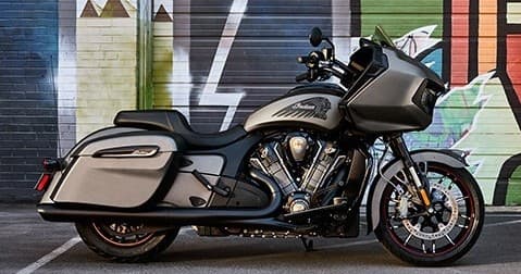 Gray Indian bagger motorcycle parked against urban mural