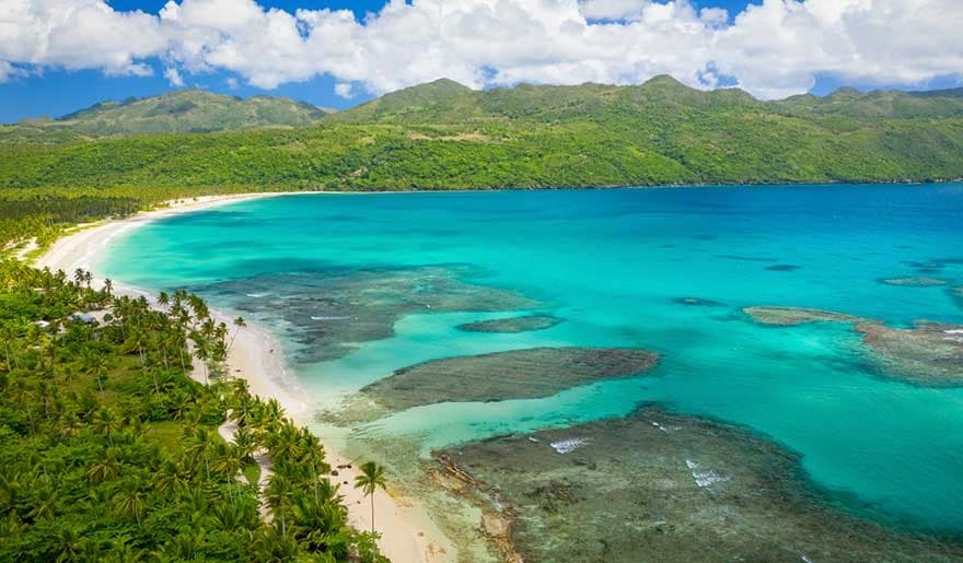 Aerial turquoise coastline and tropical beach bay, snorkeling and sunbathing