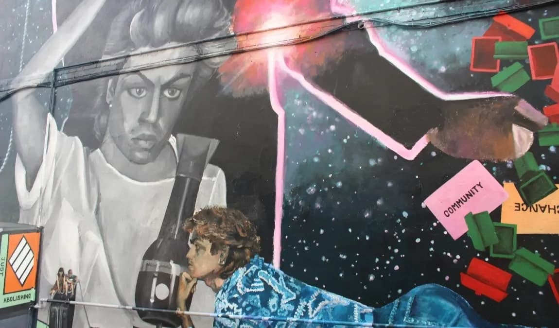Street mural of iconic musician on brick wall in urban setting