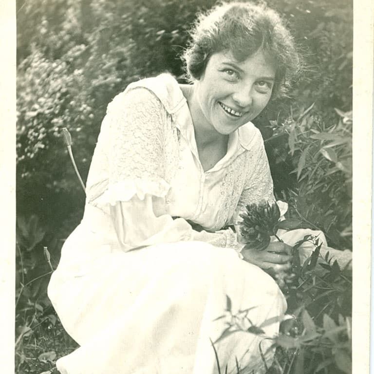 Historic portrait of woman seated in garden at museum grounds