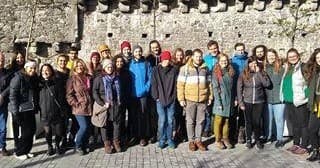 Guided group tour at historic stone castle wall outdoors