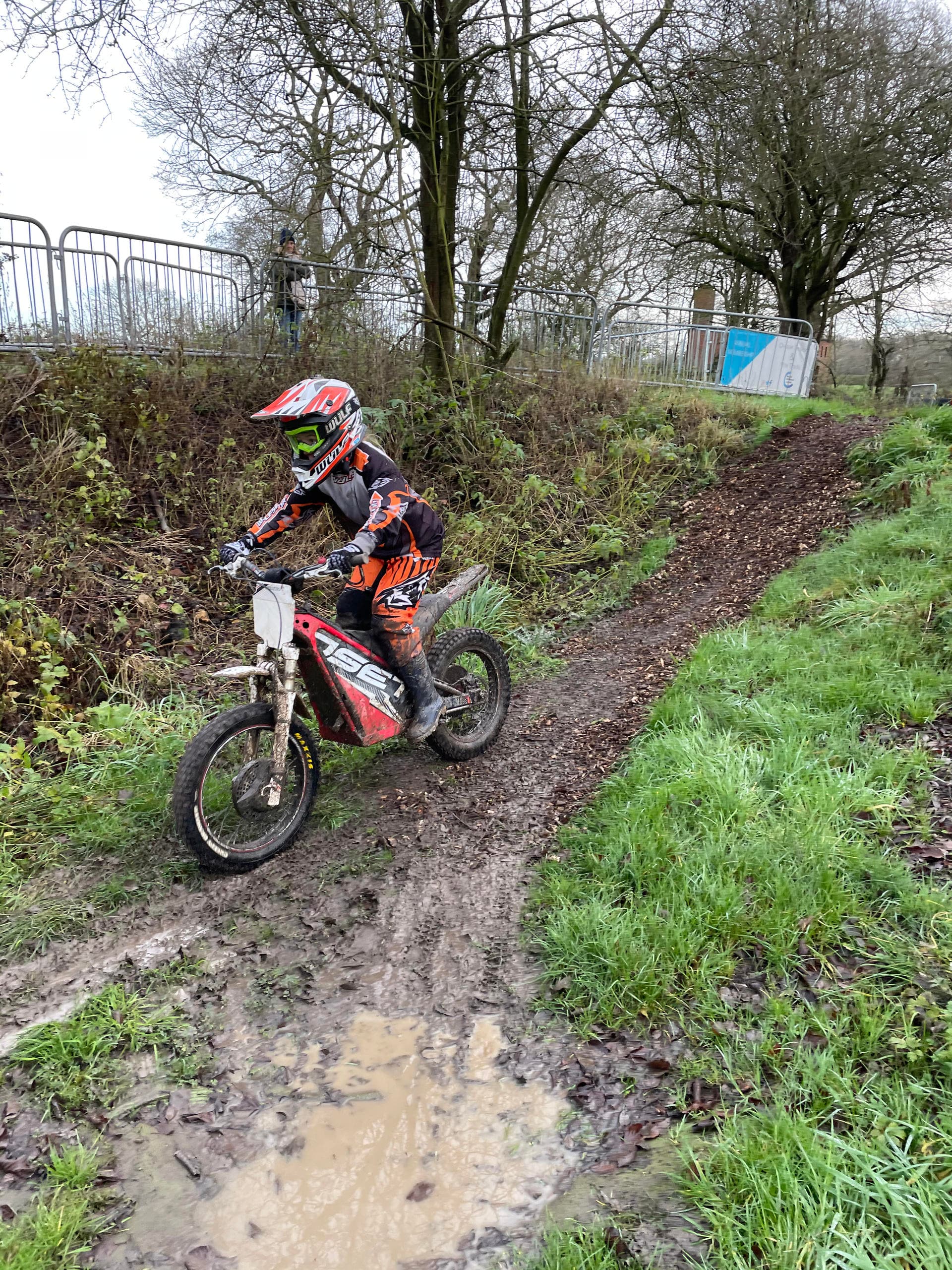 Youth motocross rider navigating muddy off-road trail