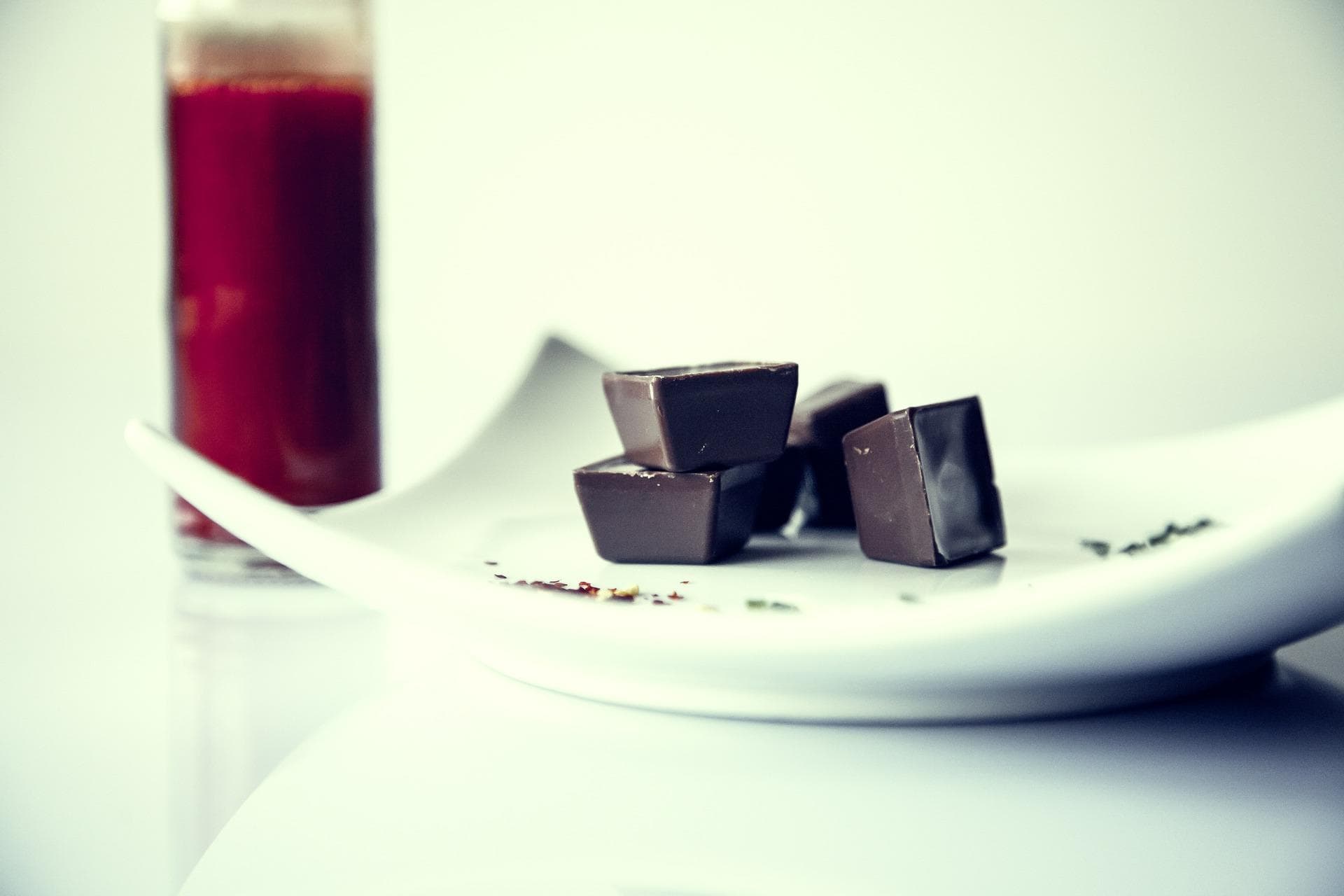 Artisan chocolate squares on plate with wine glass at tasting