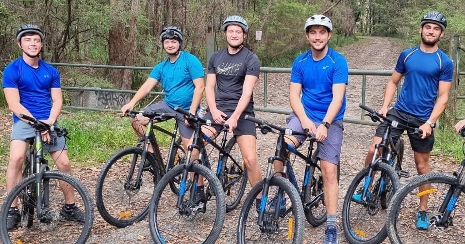 Mountain bikers on forest trail in Kangaroo Valley posing with bikes