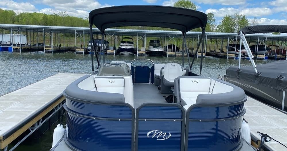 Bow view of pontoon docked at marina on sunny lake