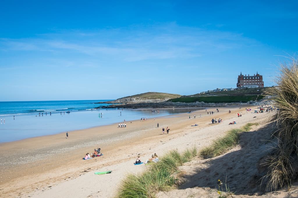 Sunny family beach near castle headland with gentle surf