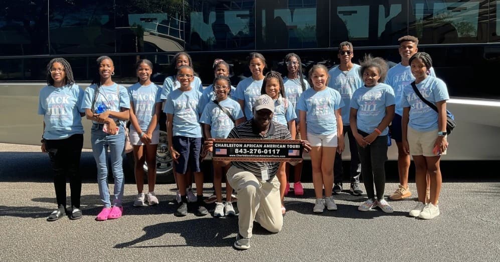 Guided walking tour group in Charleston posing by tour coach