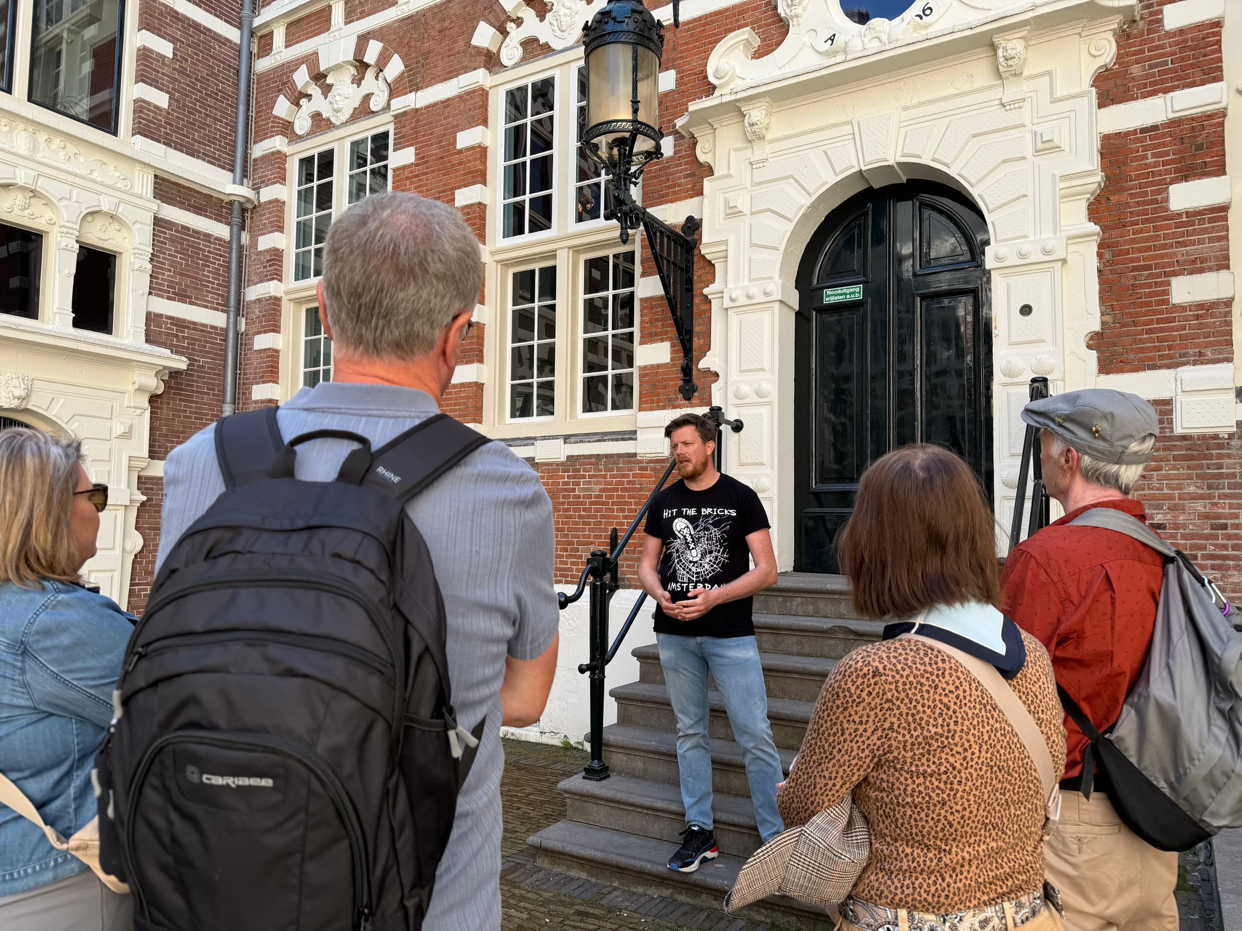 Guide leading outdoor walking tour in front of historic city facade