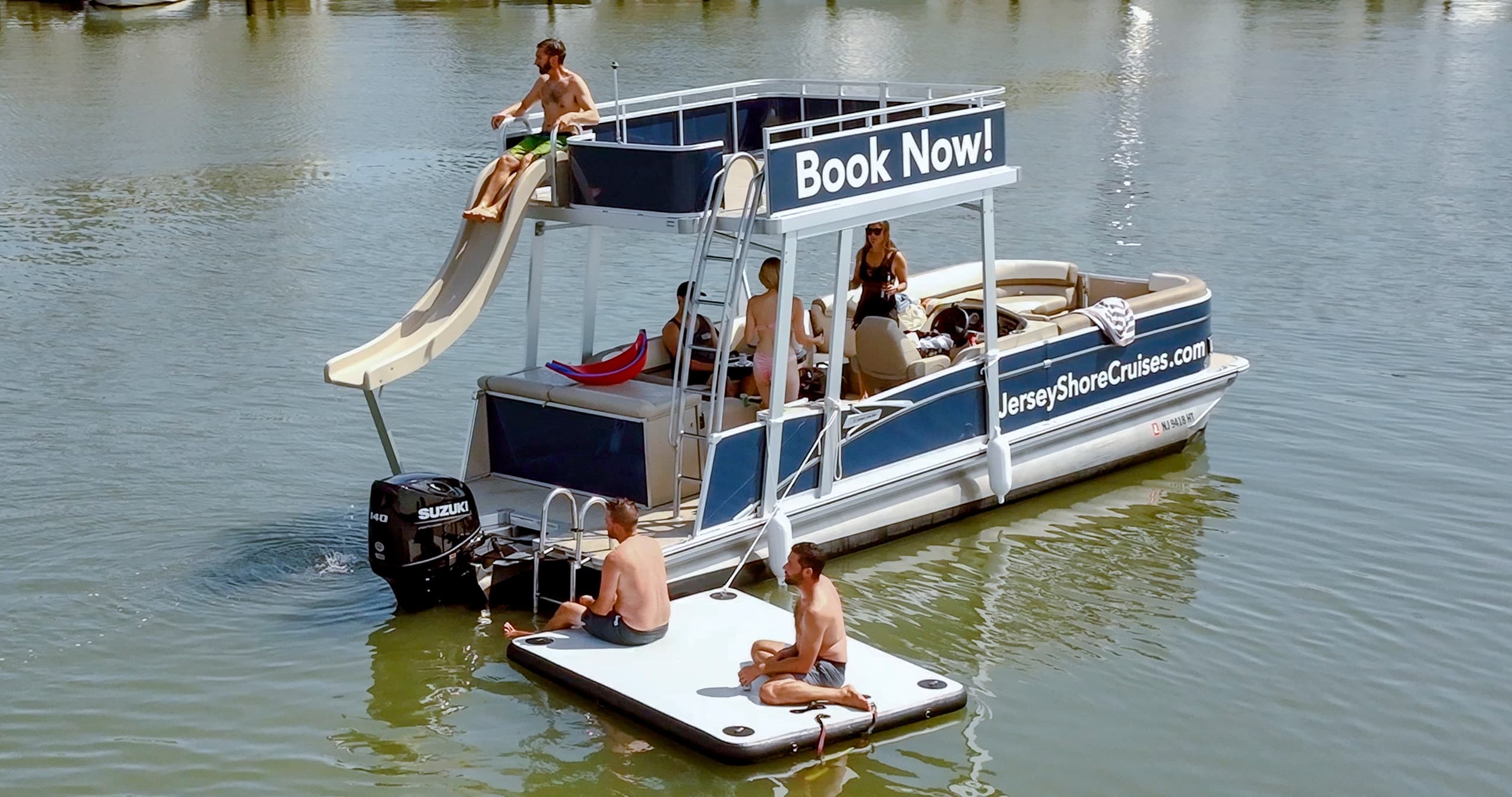 Pontoon boat with slide on calm bay waters, Jersey Shore