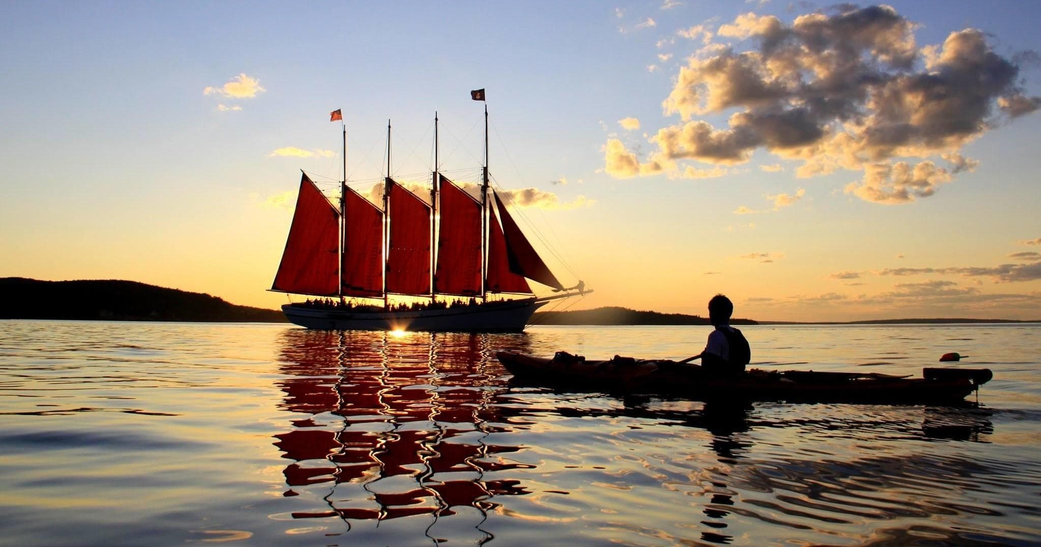 Sailboat cruising at sunset on calm coastal waters