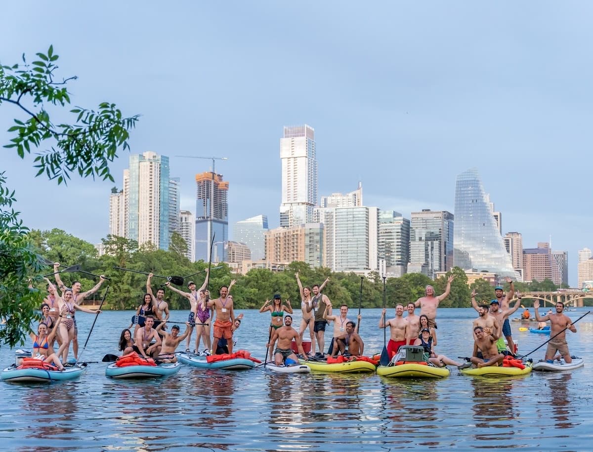 Stand-up paddleboarders on Lady Bird Lake with Austin skyline