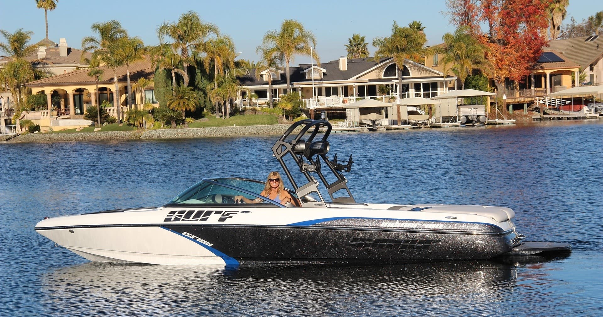 Performance ski boat cutting through lake near shore