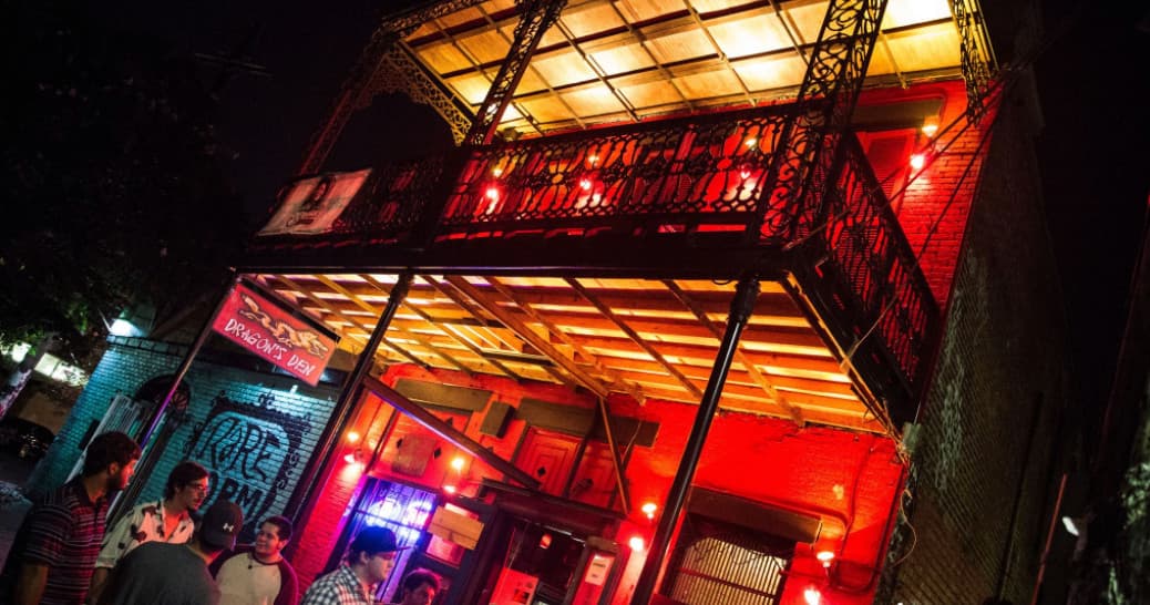Nighttime exterior of lively music bar with balcony and neon