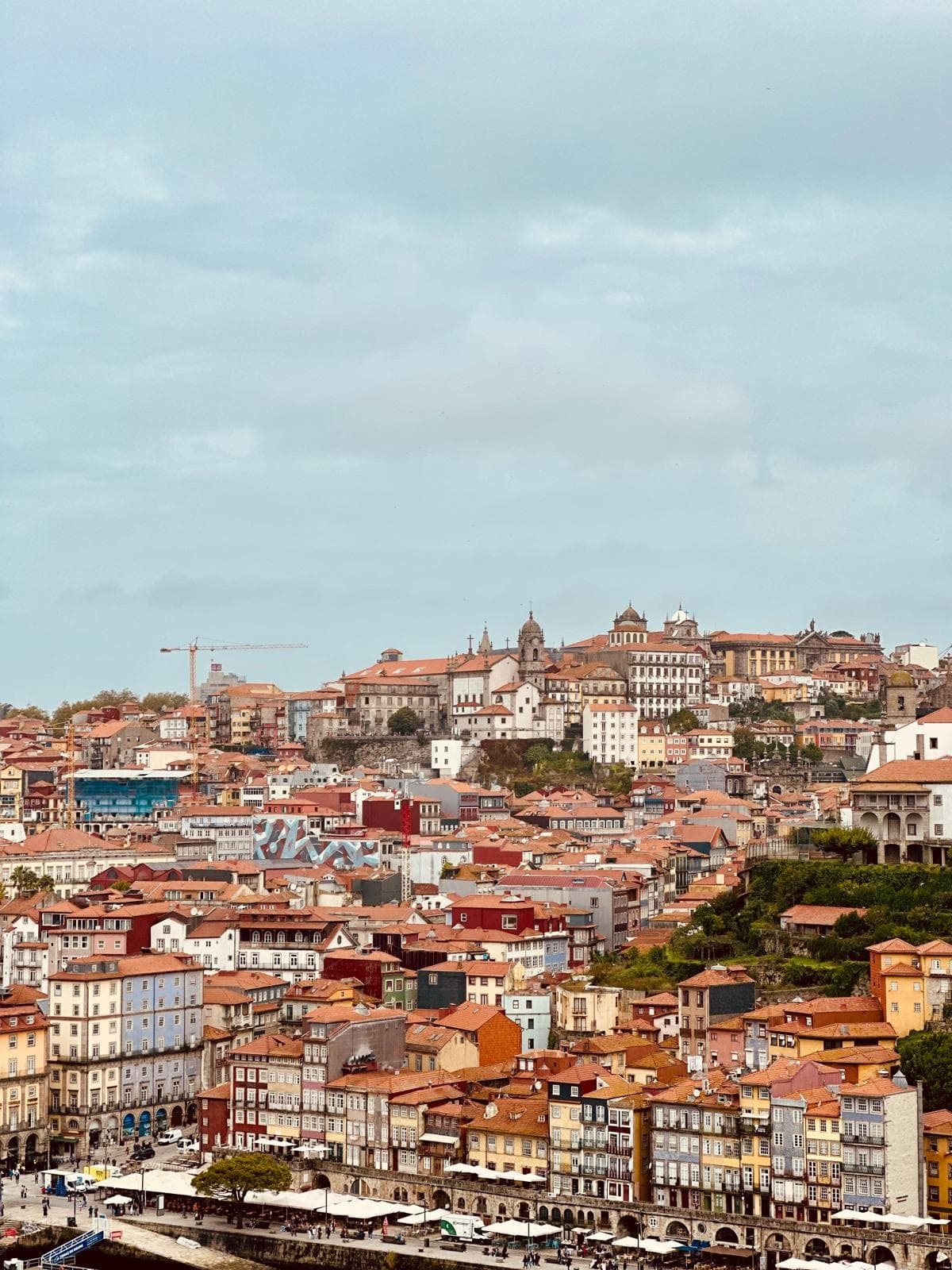 Panoramic hillside city view of Porto rooftops and riverside strolling