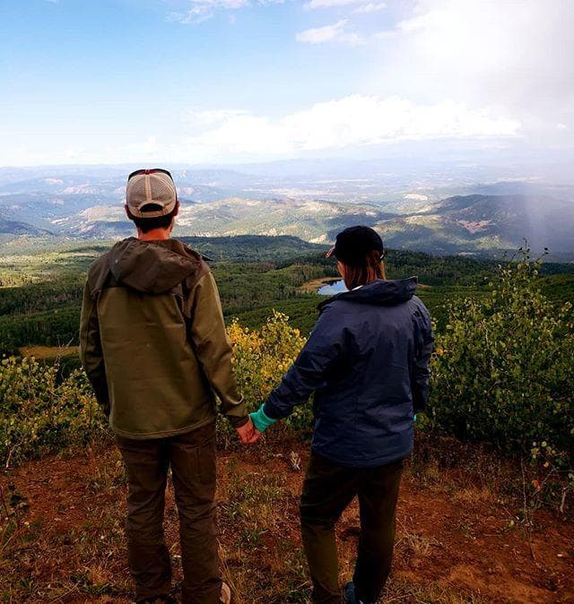 Couple overlooking expansive mountain valley at overlook