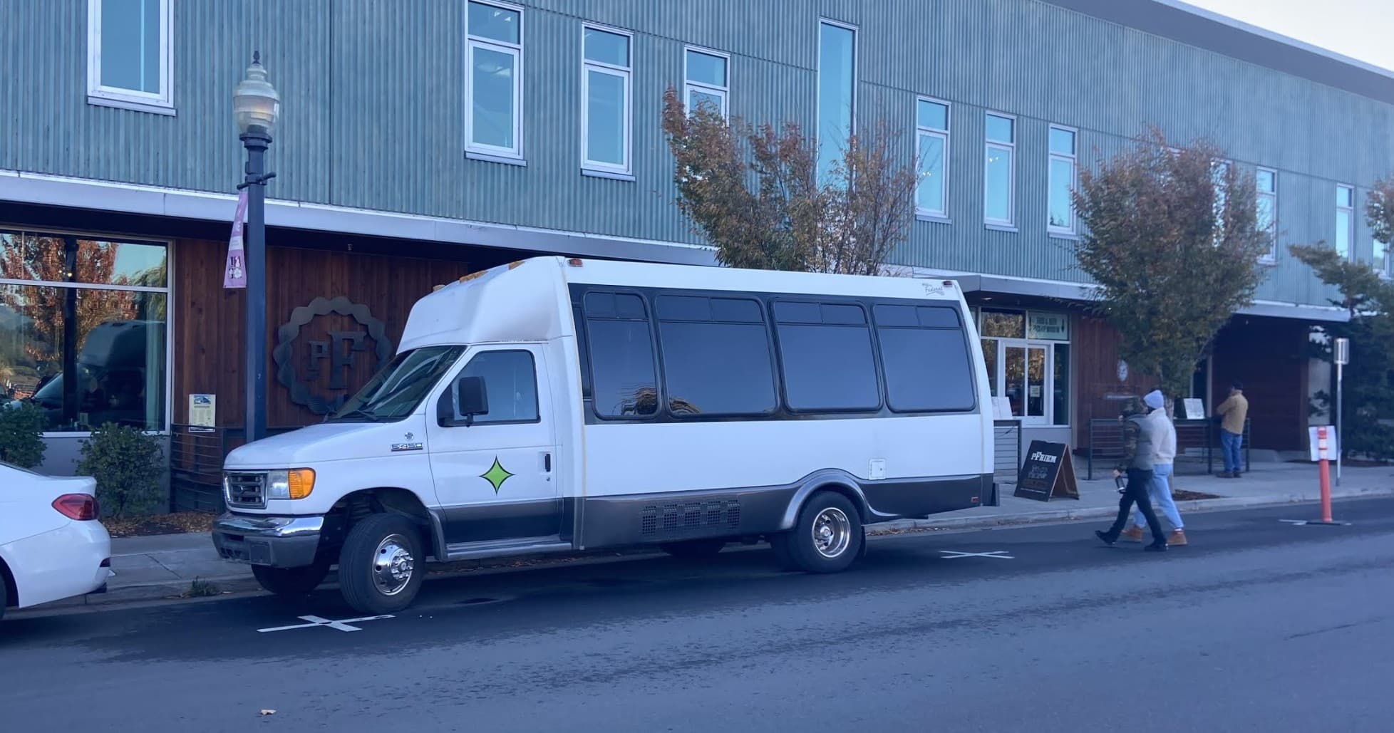 Passenger shuttle van parked on small town main street
