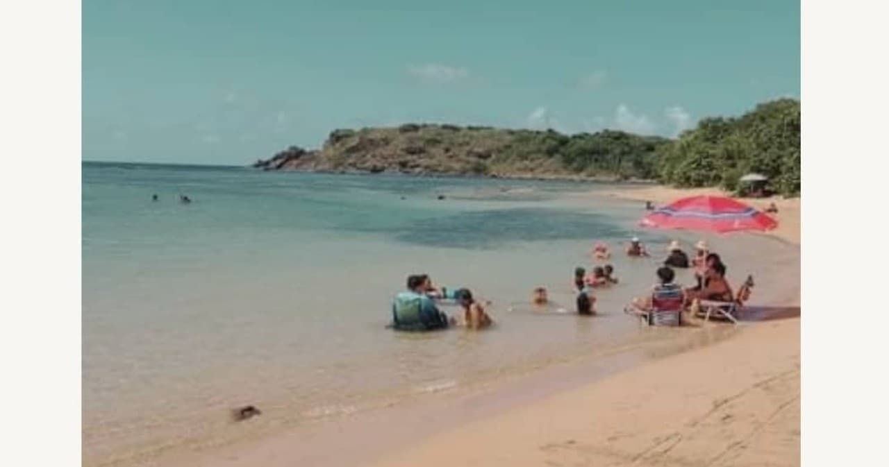 Family beach day with umbrellas on calm Caribbean shoreline