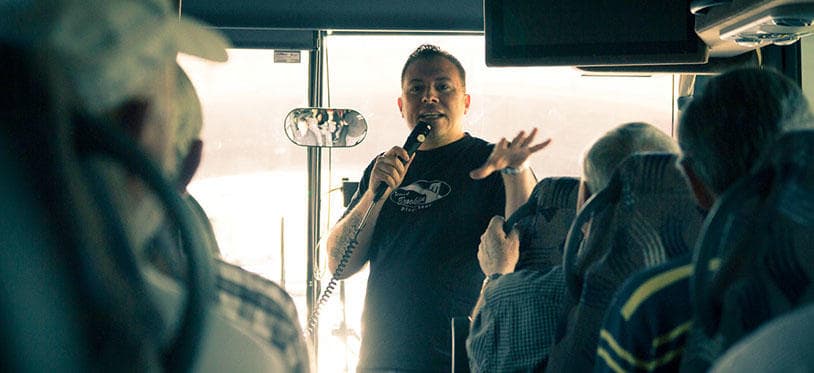 Tour guide speaking to passengers on sightseeing coach tour