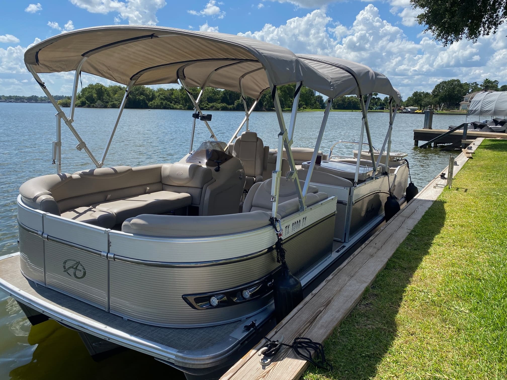 Lakeside pontoon tied to dock with seating and canopy