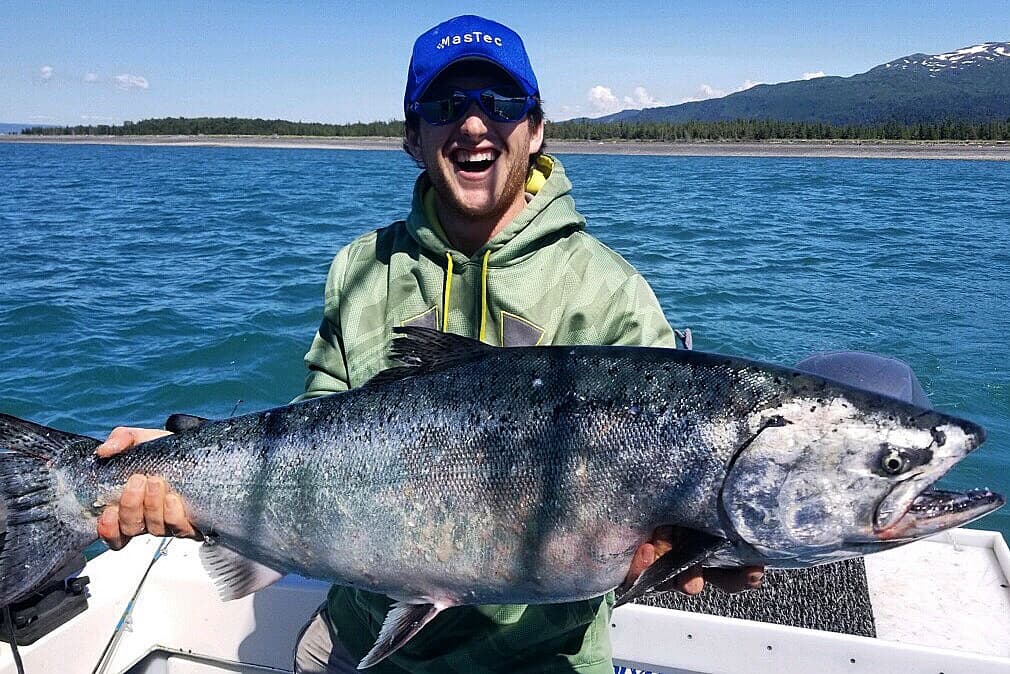 Angler holding giant king salmon on Alaskan ocean charter
