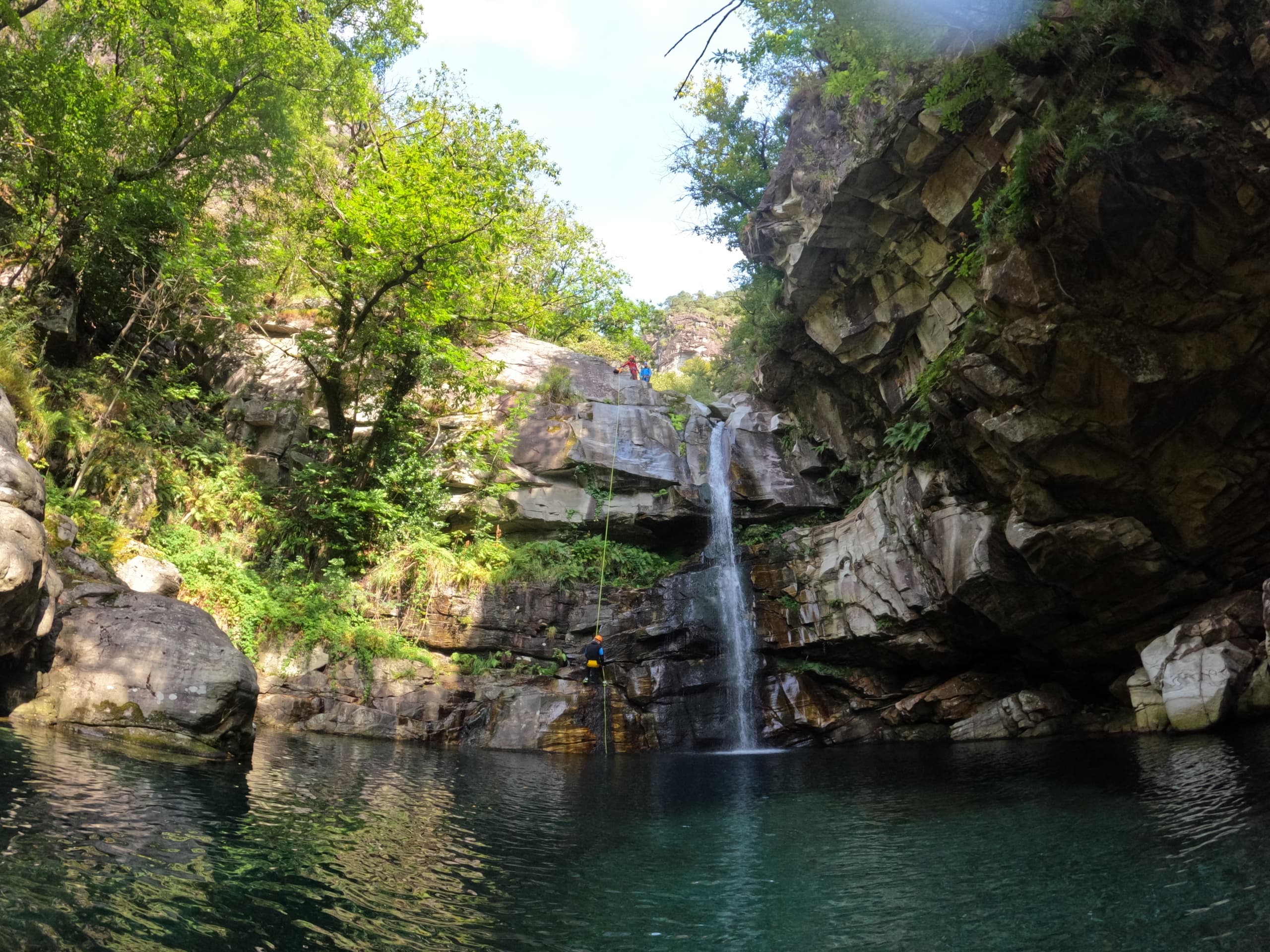 Waterfall plunging into emerald pool in alpine canyon