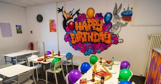 Birthday party room with tables, balloons inside trampoline venue