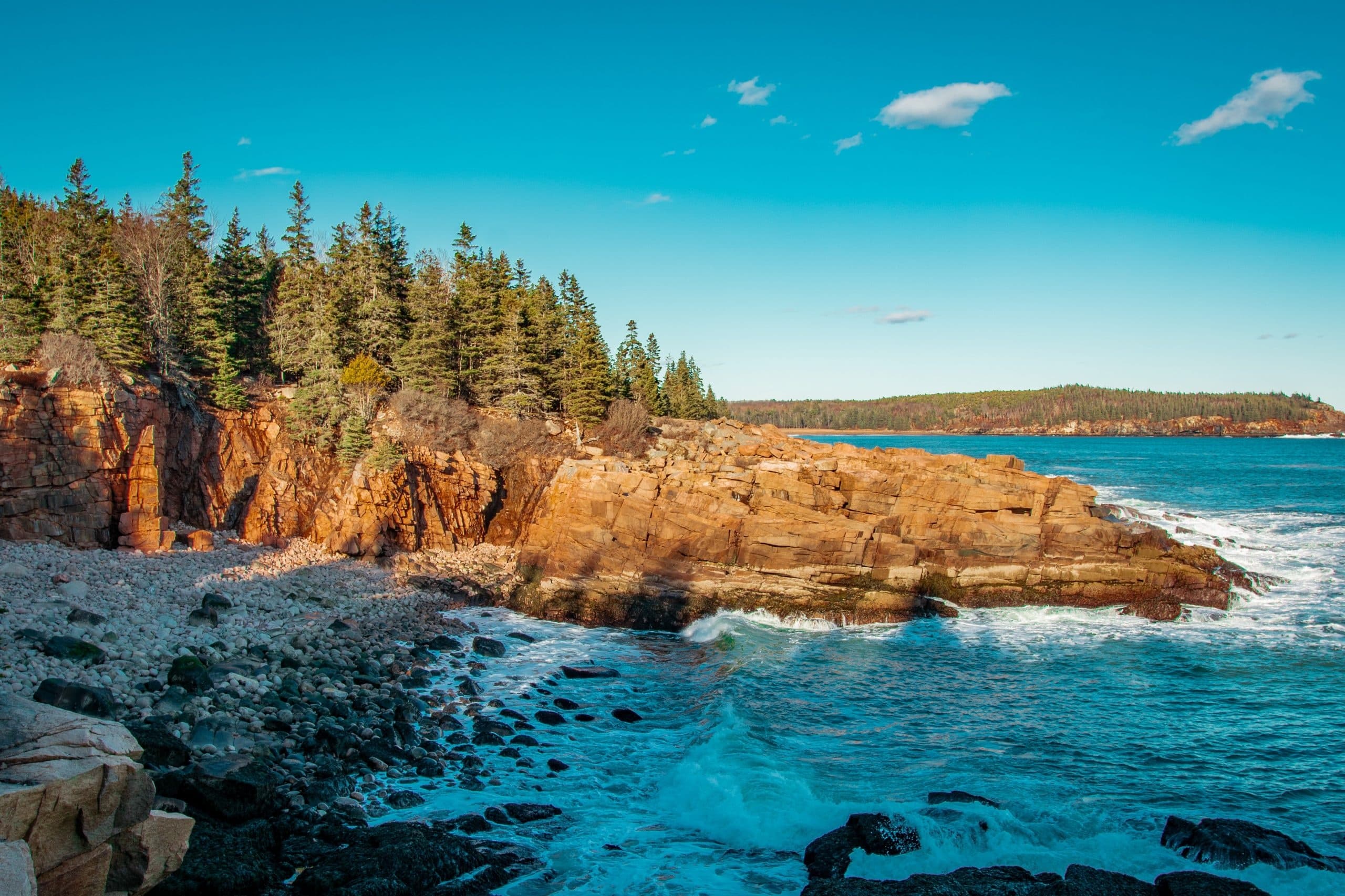 Rocky Atlantic coastline with crashing waves and forested cliffs