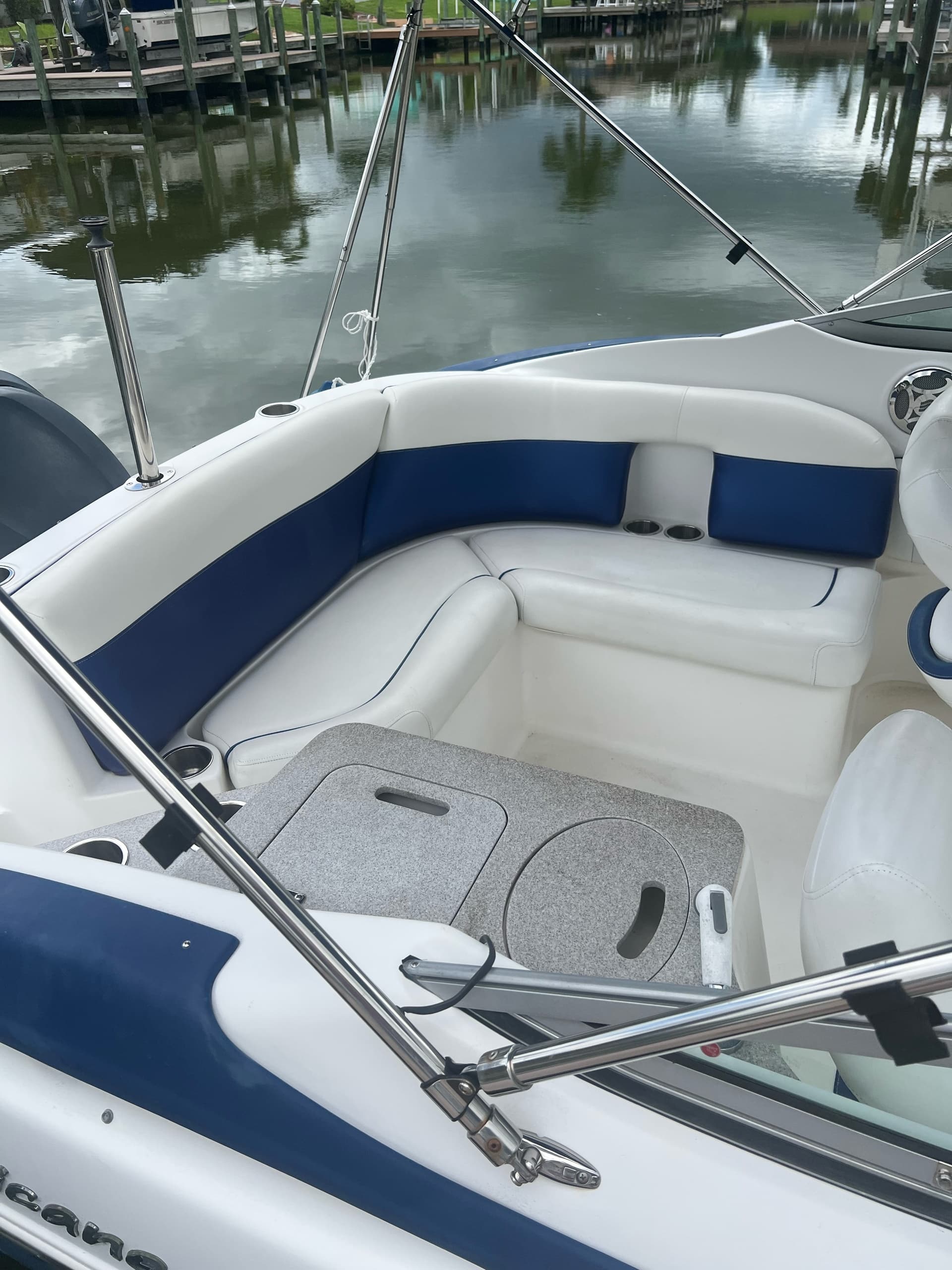 Bow seating of white-blue boat docked at calm marina