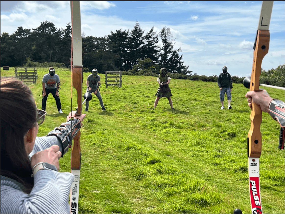 Archers practicing field archery on grassy open range