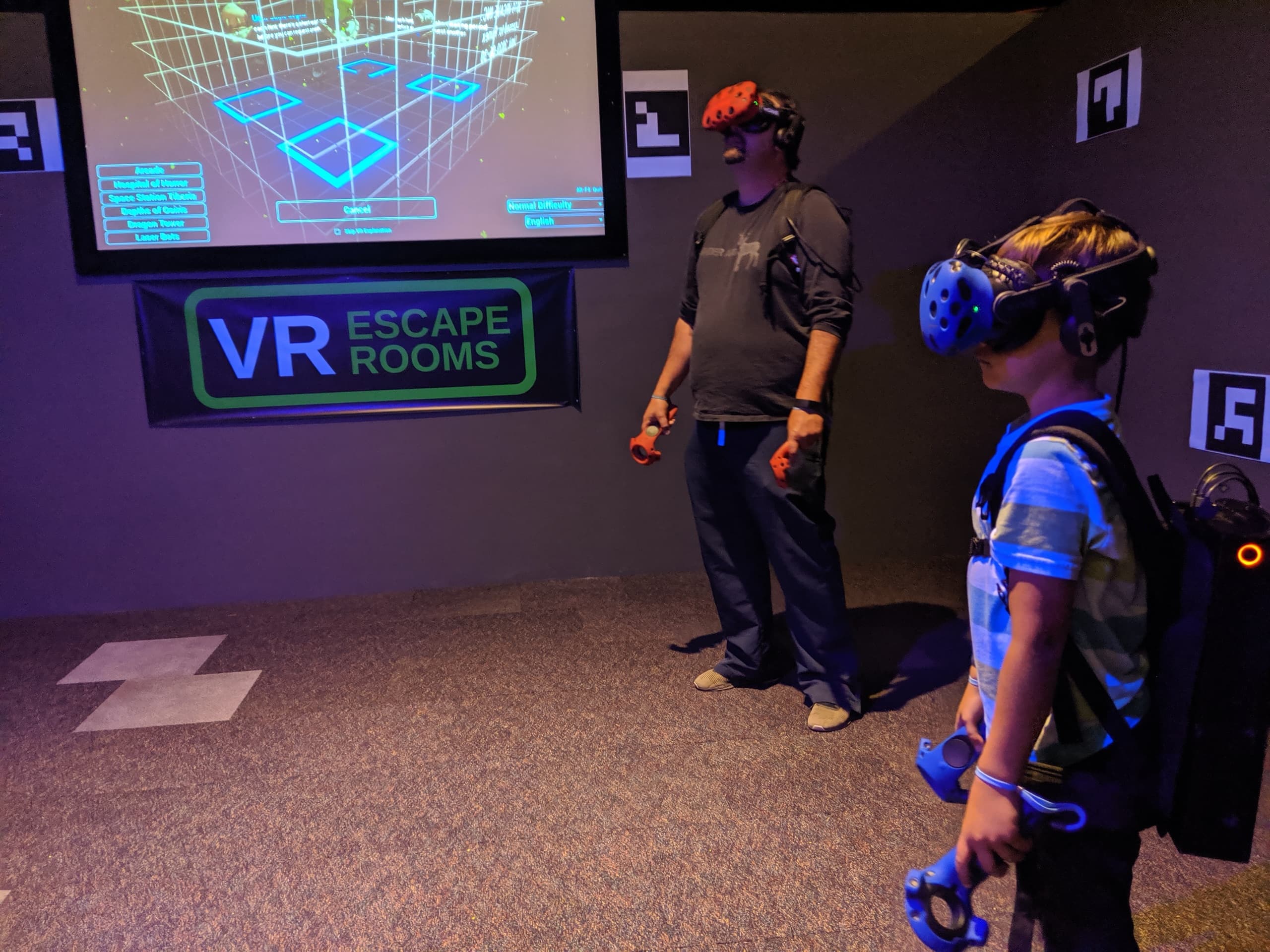 Players in VR escape room using headsets and trackers indoors