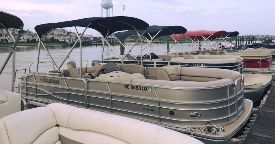 Pontoon boats docked at coastal marina ready for rentals
