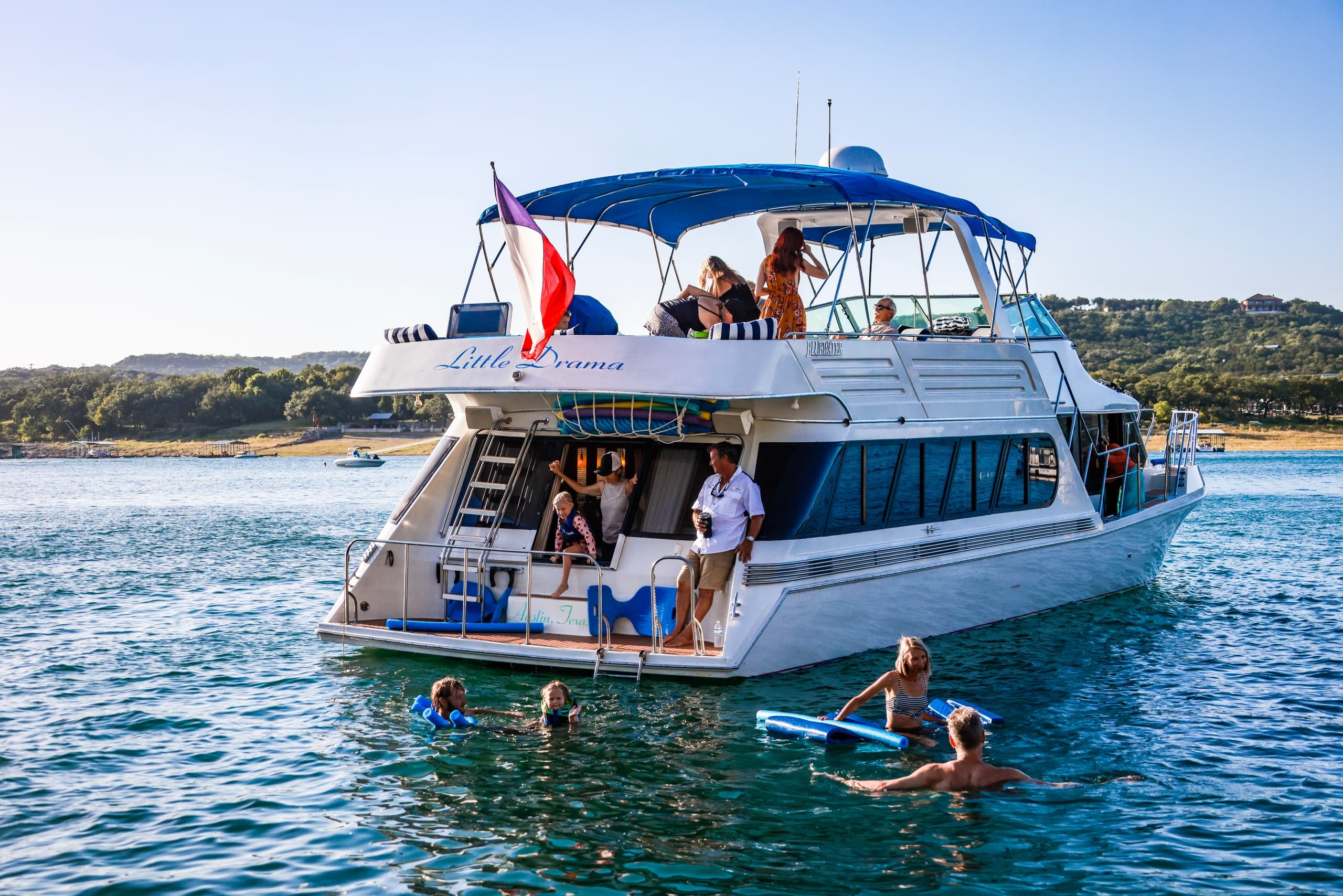Guests swimming from charter yacht in coastal blue waters
