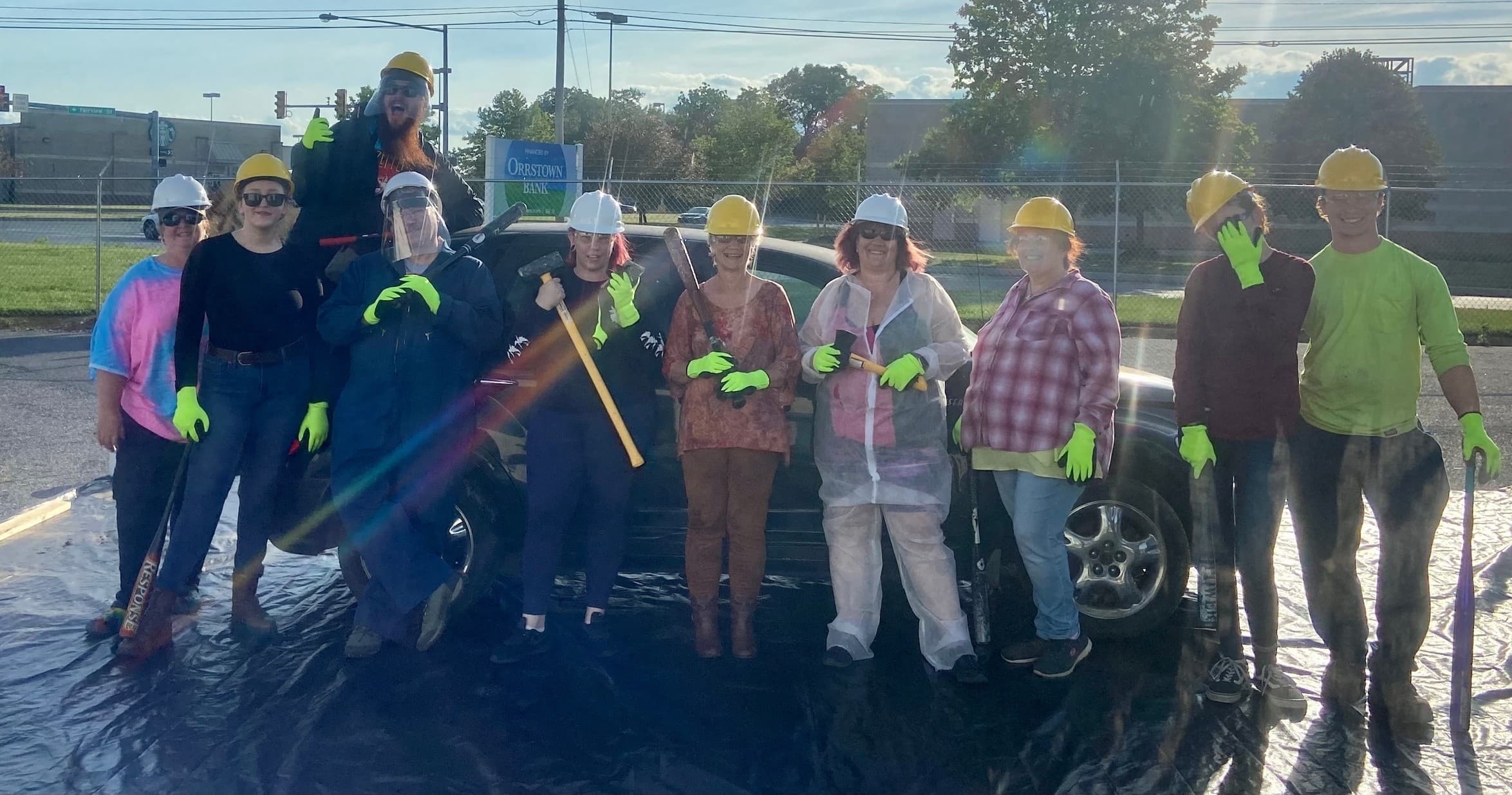 Outdoor volunteer crew in hard hats performing community cleanup in field