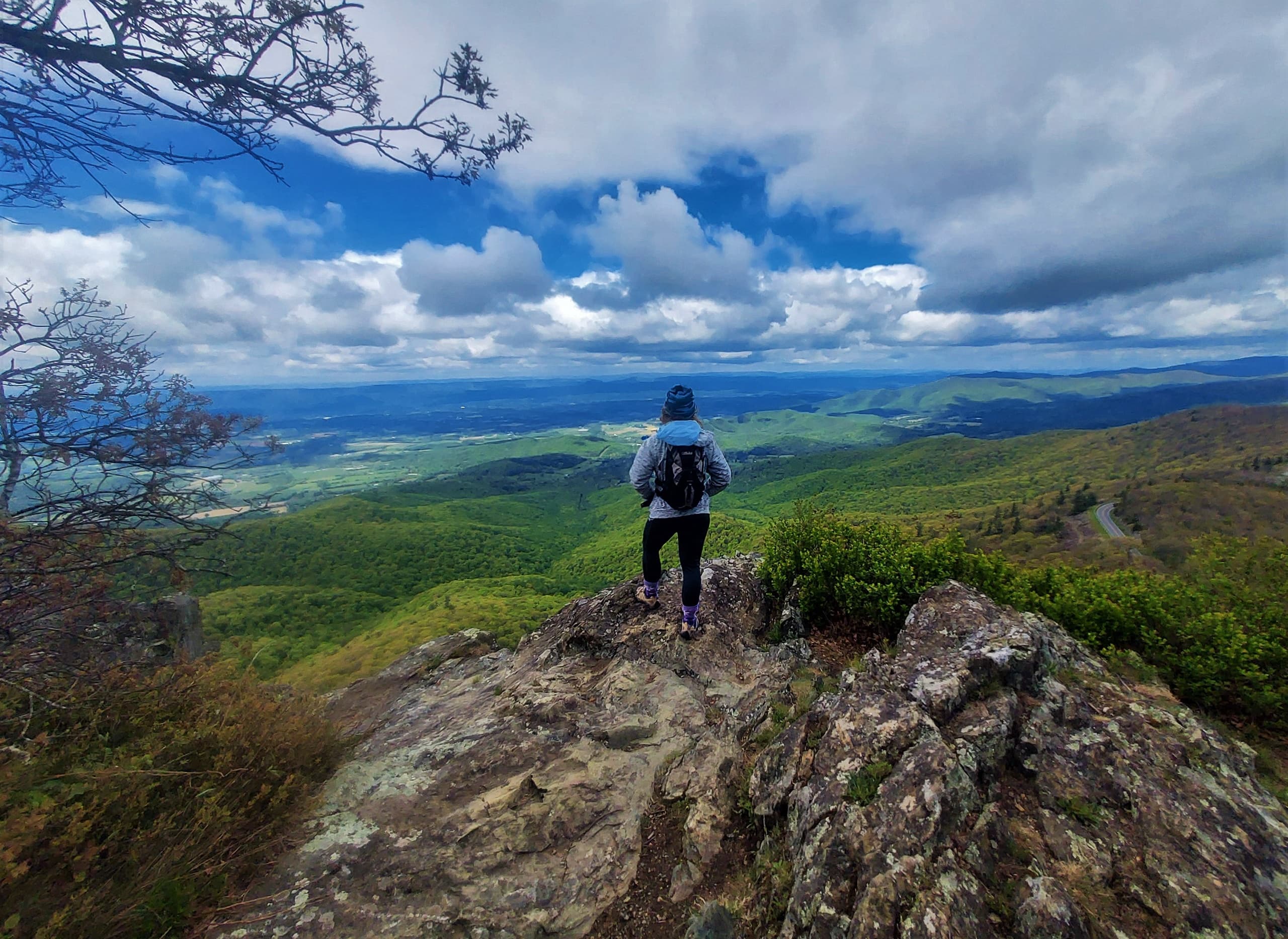 Backpacker hiking mountain ridge overlooking valley vista