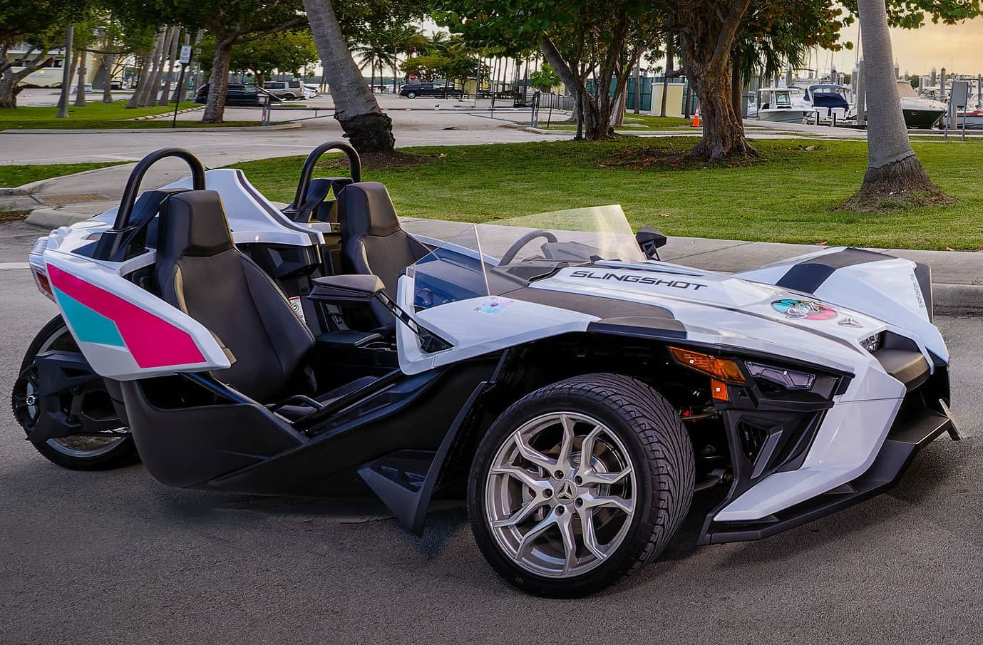 White slingshot parked on waterfront park road, open-air tour