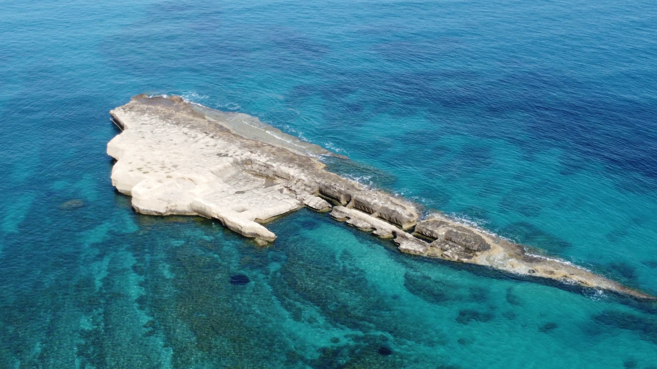 Aerial view of rocky islet and turquoise Mediterranean waters