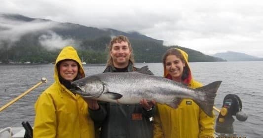 Three anglers displaying king salmon on Alaskan sportfishing trip