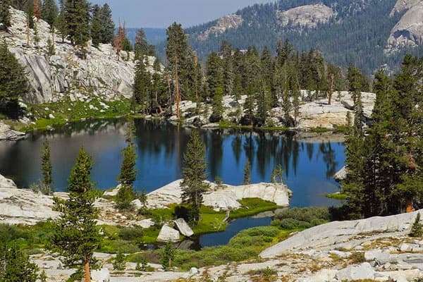 Pristine alpine lake framed by granite peaks, backcountry hiking