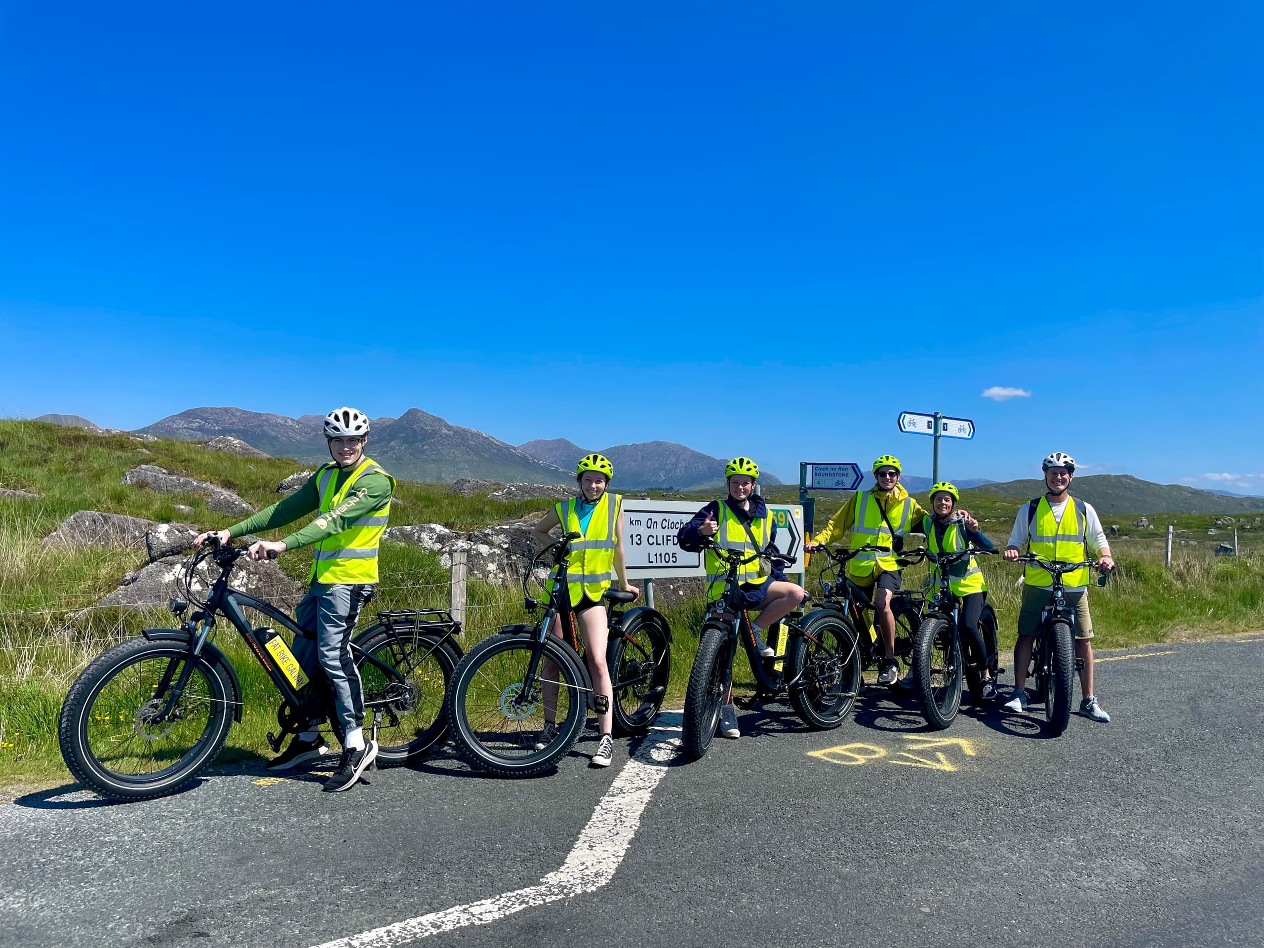 Cyclists on fat-bikes at roadside with sweeping Galway mountain views