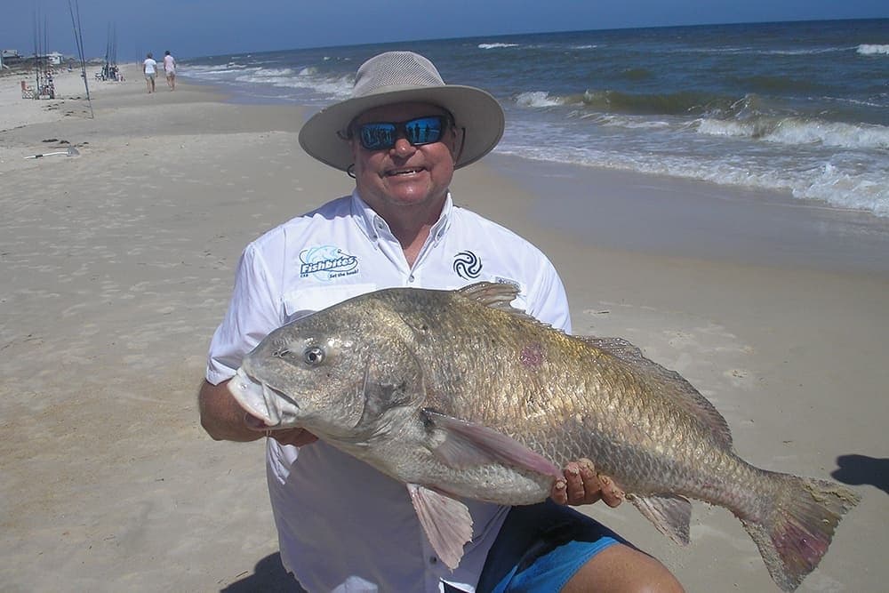 Fisherman proudly displaying big catch on shoreline