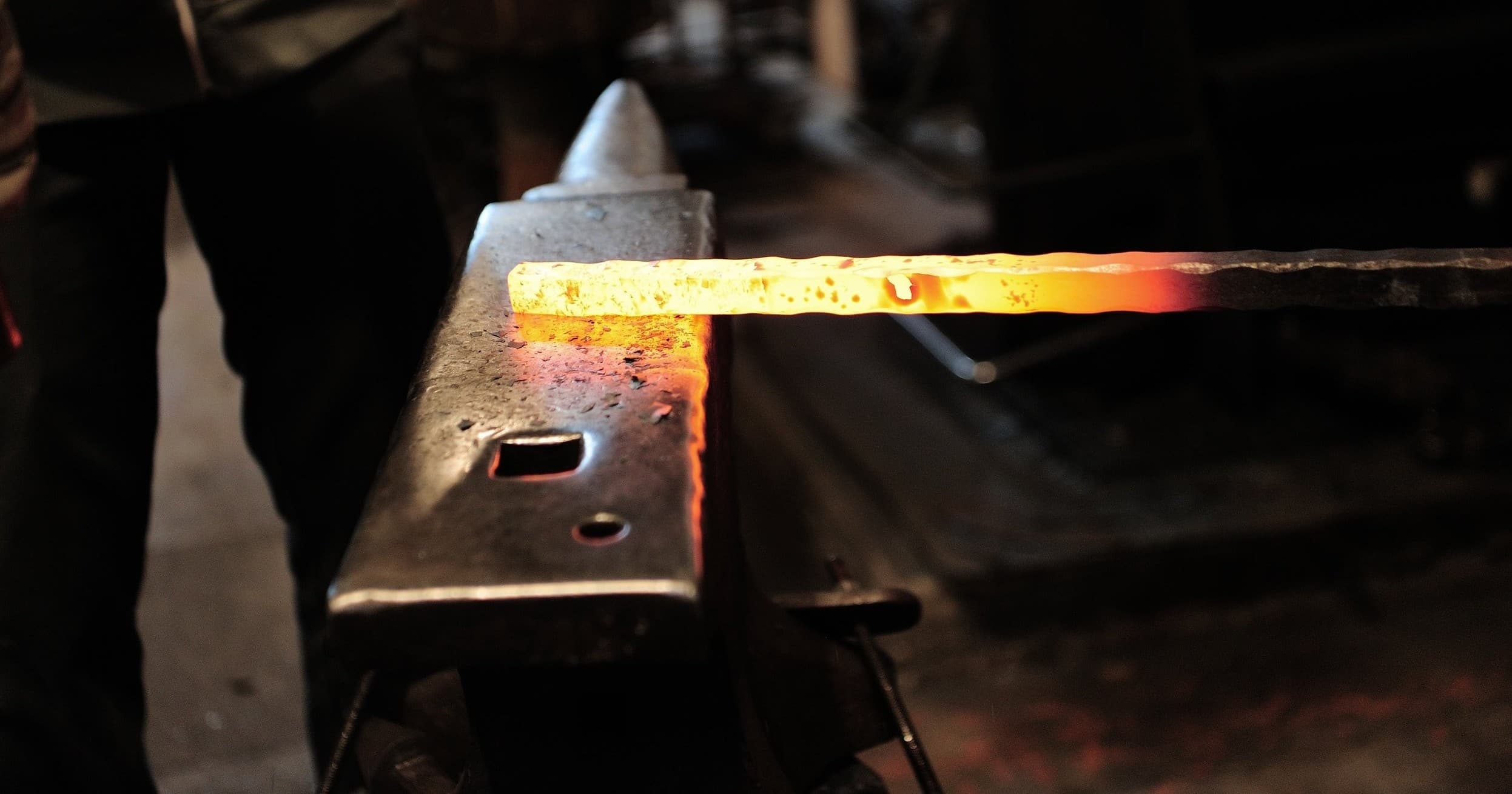 Glowing hot steel on anvil during forging in studio