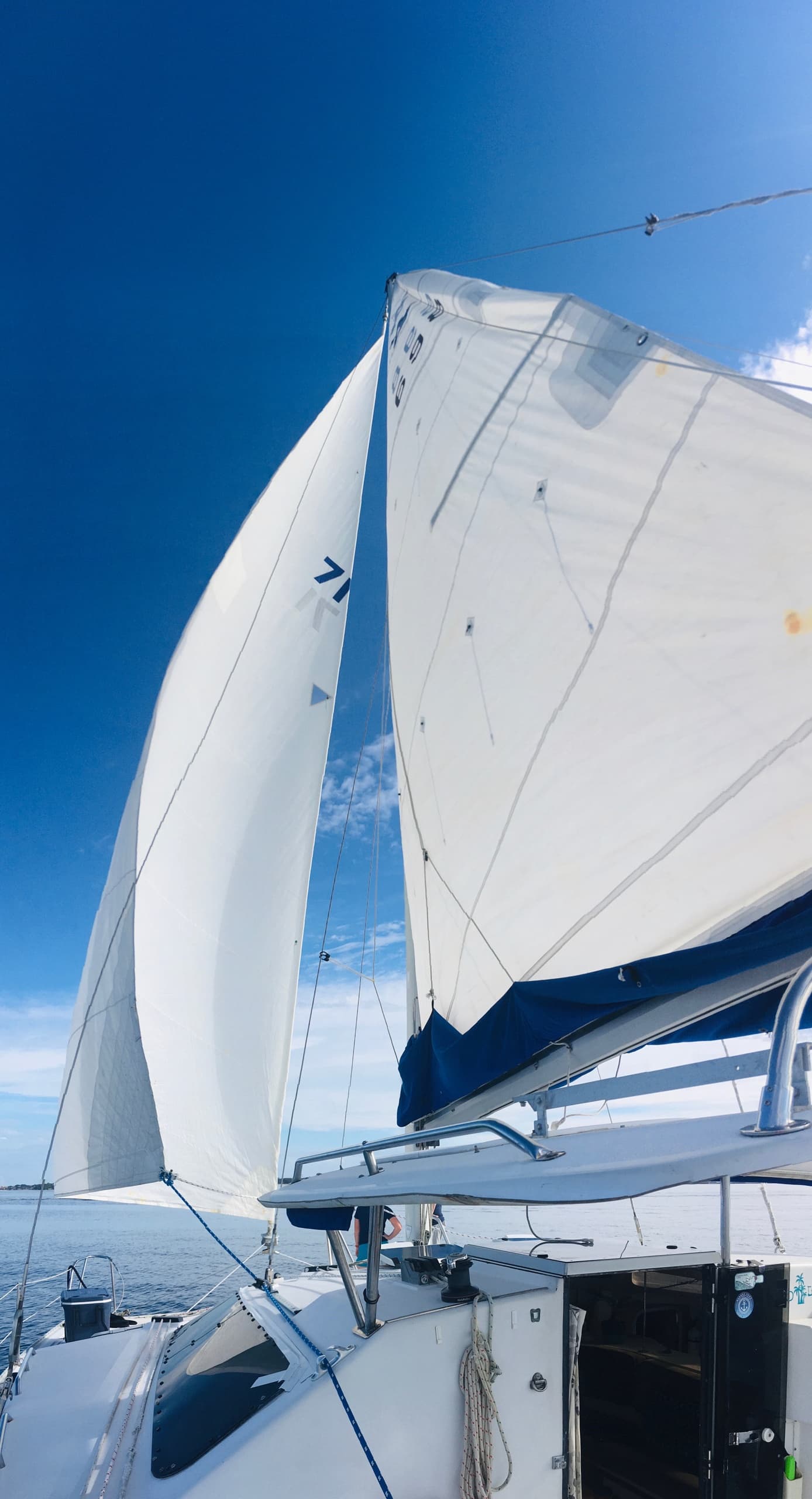 Close-up sail and rigging aboard yacht under blue sky, sailing